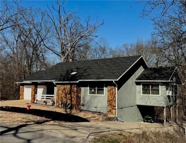 view of front of house featuring roof with shingles, an attached garage, driveway, and crawl space