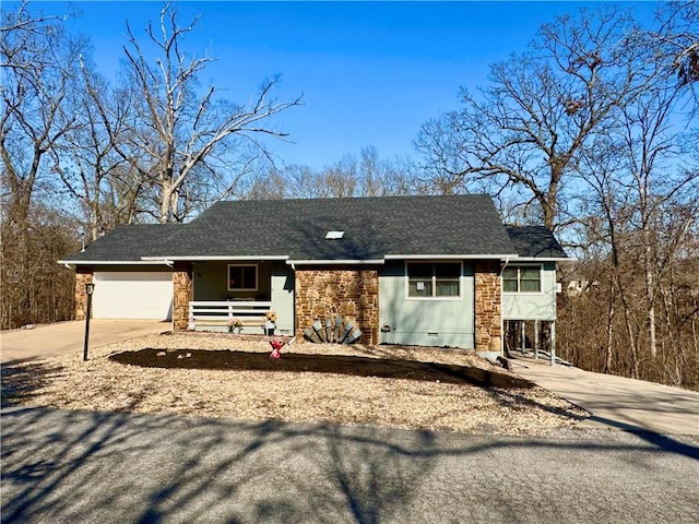 ranch-style home with stone siding, a porch, concrete driveway, an attached garage, and a shingled roof