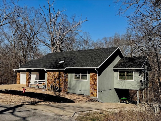 view of front of property featuring a garage, roof with shingles, and concrete driveway