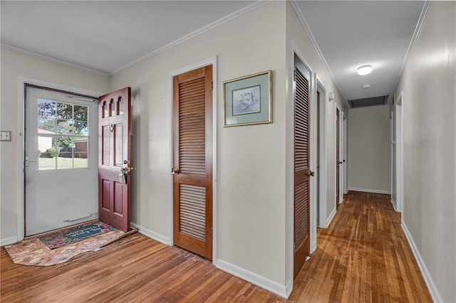 entryway with crown molding and wood-type flooring