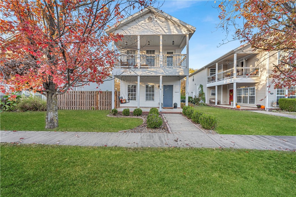 view of front of property featuring a front yard and a balcony