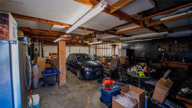 garage with a garage door opener and freestanding refrigerator