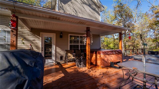 wooden deck with a hot tub and a grill