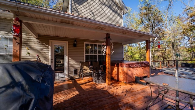 deck with grilling area and a hot tub