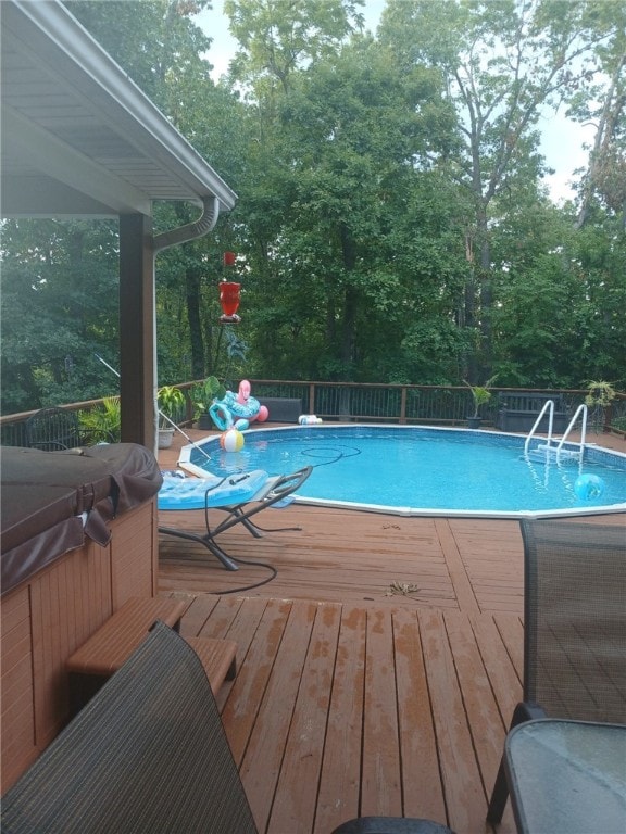 view of pool featuring a hot tub, a deck, and a fenced in pool