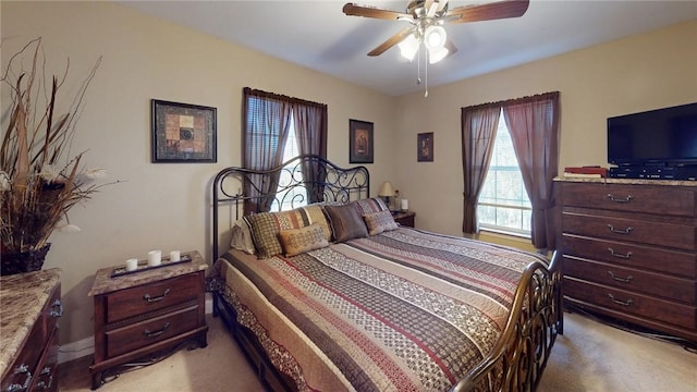 bedroom with a ceiling fan and light colored carpet