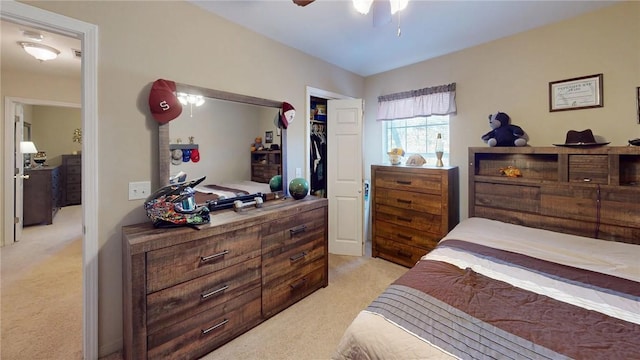 bedroom featuring a closet, light colored carpet, and ceiling fan