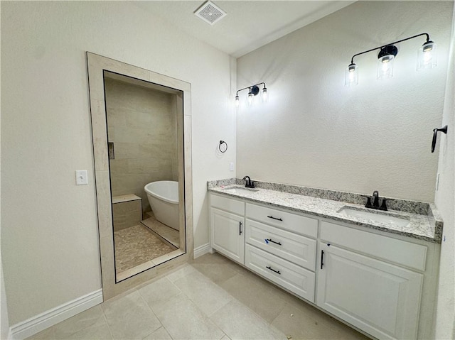 bathroom with tile patterned flooring, a bathtub, and vanity