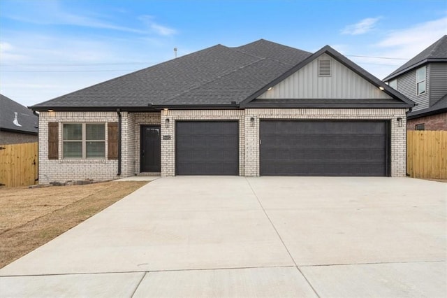 6602 SW Spindle St, Bentonville, AR 72713 - view of front of home featuring driveway, roof with shingles, fence, brick siding, and a garage