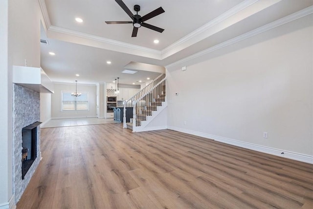 6602 SW Spindle St, Bentonville, AR 72713 - unfurnished living room with light wood finished floors, stairs, ornamental molding, ceiling fan with notable chandelier, and a glass covered fireplace