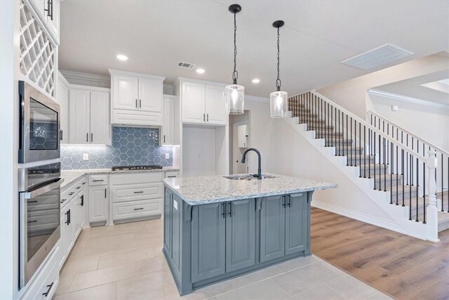 6602 SW Spindle St, Bentonville, AR 72713 - kitchen featuring white cabinets, visible vents, crown molding, stainless steel appliances, and a sink