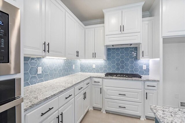 6602 SW Spindle St, Bentonville, AR 72713 - kitchen featuring white cabinets, light stone counters, tasteful backsplash, and appliances with stainless steel finishes