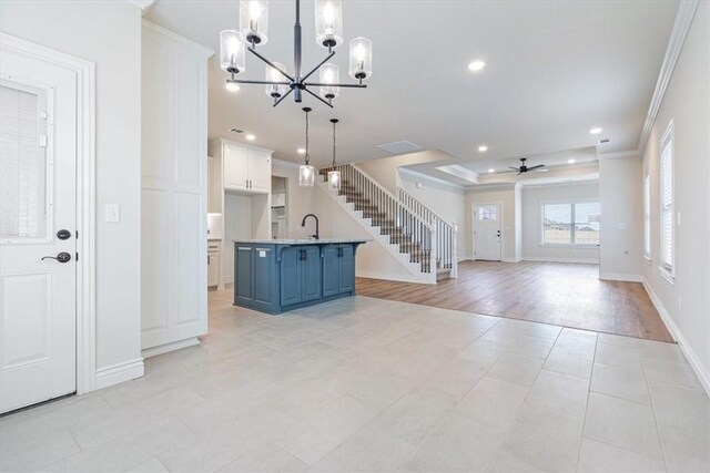 6602 SW Spindle St, Bentonville, AR 72713 - unfurnished living room featuring a sink, a raised ceiling, baseboards, ceiling fan with notable chandelier, and recessed lighting
