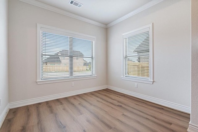 6602 SW Spindle St, Bentonville, AR 72713 - spare room featuring baseboards, visible vents, wood finished floors, and ornamental molding