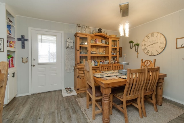 dining space with a chandelier, hardwood / wood-style floors, and ornamental molding