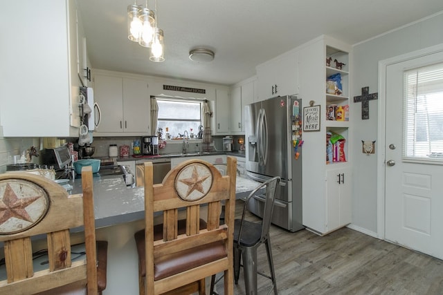 kitchen featuring plenty of natural light, white cabinetry, appliances with stainless steel finishes, and tasteful backsplash