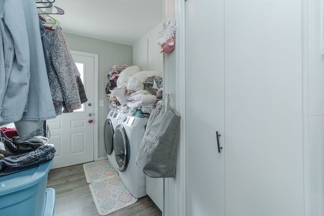 laundry area featuring light hardwood / wood-style flooring and washing machine and clothes dryer