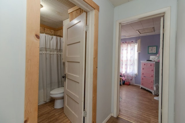 bathroom featuring hardwood / wood-style flooring, curtained shower, and toilet