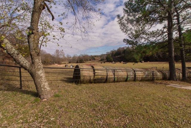 yard at dusk featuring a rural view