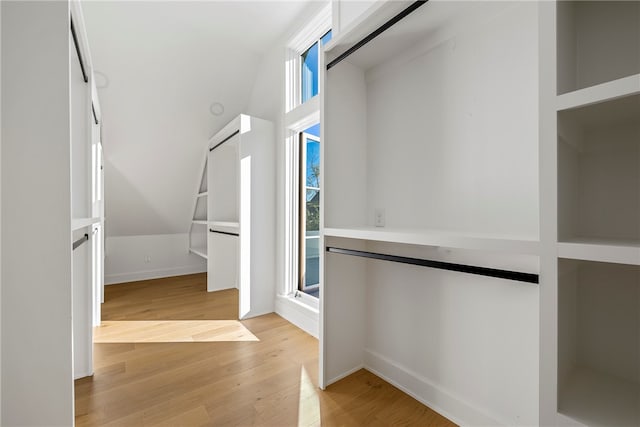 spacious closet featuring light wood-type flooring and vaulted ceiling