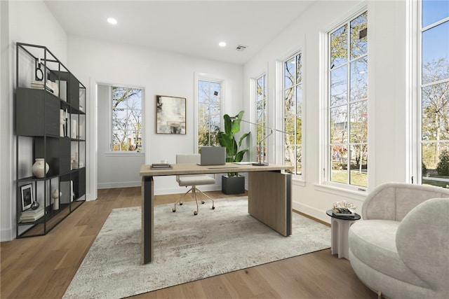 office space with dark wood-type flooring and a healthy amount of sunlight