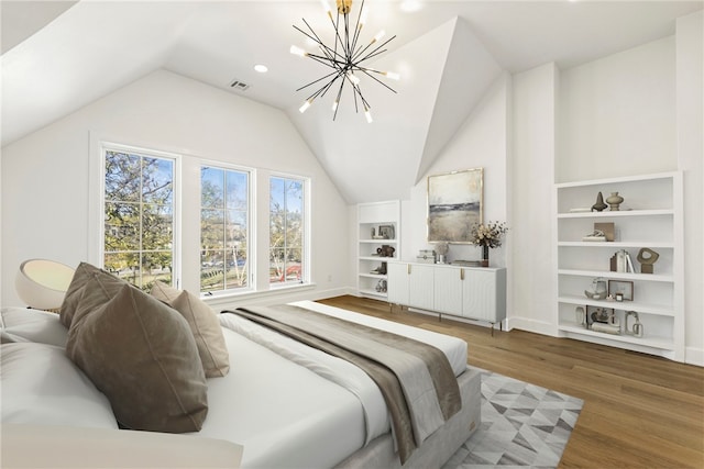 bedroom featuring hardwood / wood-style floors, lofted ceiling, and a chandelier