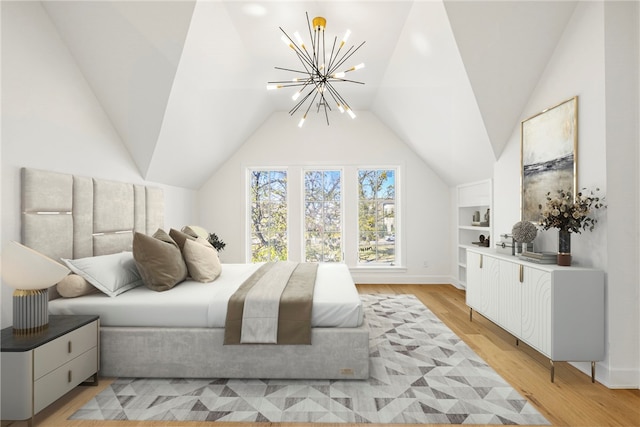 bedroom featuring light hardwood / wood-style floors, vaulted ceiling, and an inviting chandelier