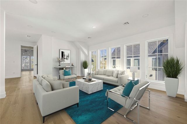 living room with light wood-type flooring, plenty of natural light, and ceiling fan