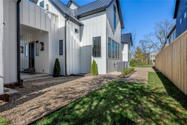 view of property exterior featuring a lawn and cooling unit