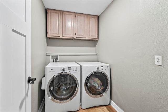 washroom with independent washer and dryer, cabinets, and light wood-type flooring