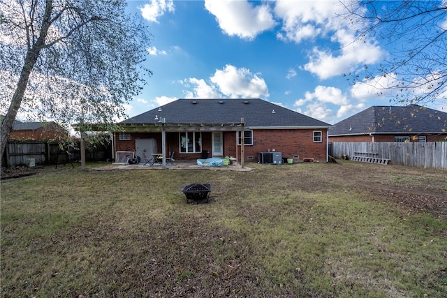 back of property featuring a yard, a patio, and an outdoor fire pit