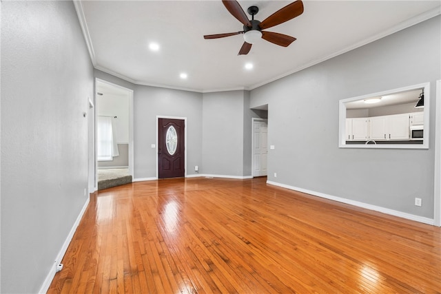 foyer with crown molding, light hardwood / wood-style flooring, and ceiling fan