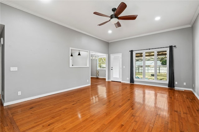 empty room with ornamental molding, ceiling fan with notable chandelier, and hardwood / wood-style flooring