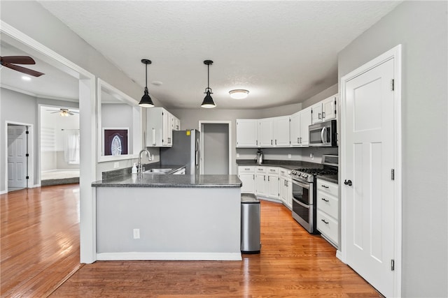 kitchen featuring hardwood / wood-style floors, white cabinetry, and appliances with stainless steel finishes