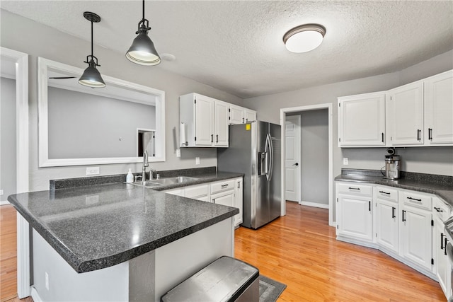 kitchen featuring kitchen peninsula, stainless steel refrigerator with ice dispenser, light wood-type flooring, sink, and white cabinetry