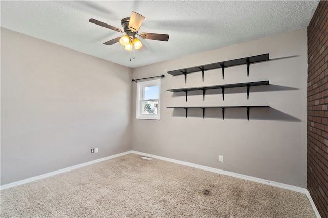 empty room with carpet flooring, ceiling fan, and a textured ceiling