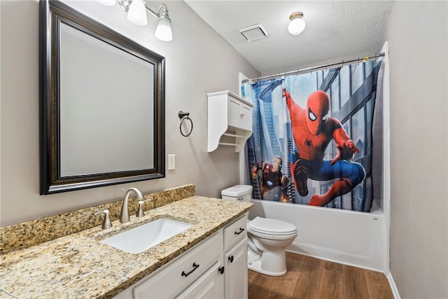 full bathroom featuring shower / bathtub combination with curtain, wood-type flooring, a textured ceiling, toilet, and vanity