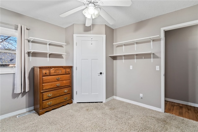 interior space with carpet floors and ceiling fan