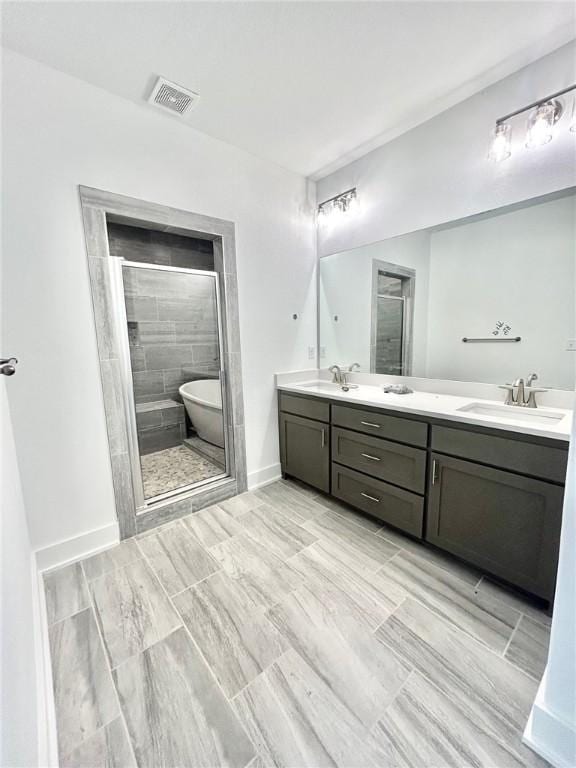 bathroom with double vanity, a sink, visible vents, and a shower stall