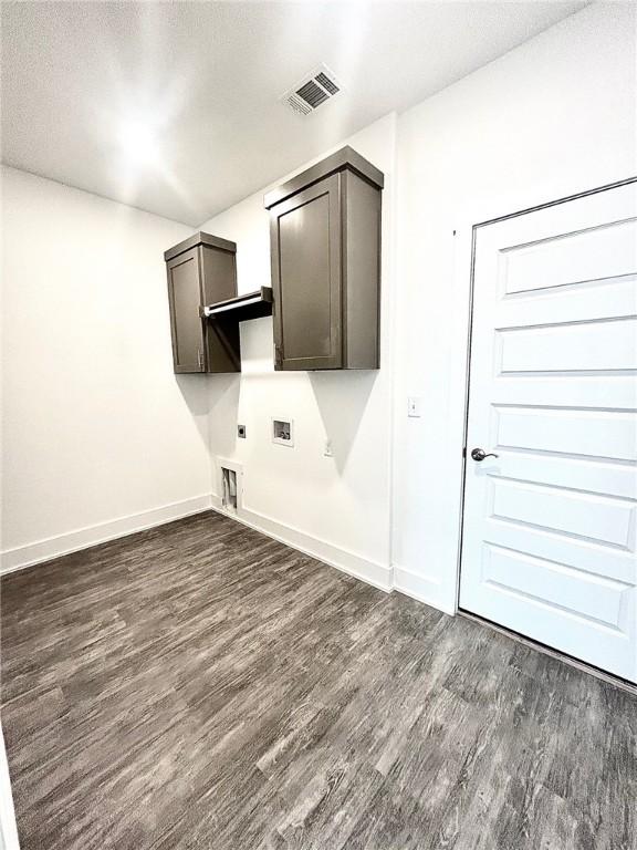 washroom featuring cabinet space, baseboards, visible vents, dark wood-style flooring, and electric dryer hookup