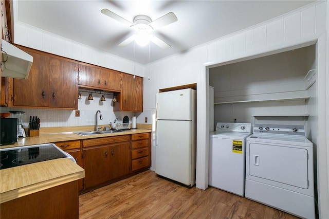 kitchen featuring ceiling fan, sink, light hardwood / wood-style flooring, washer and clothes dryer, and white refrigerator