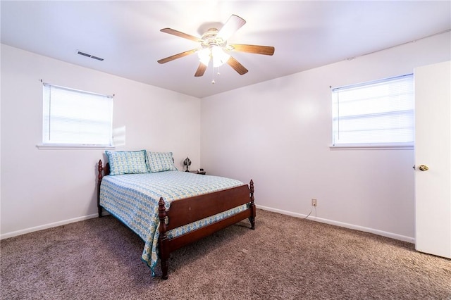 bedroom featuring ceiling fan, multiple windows, and carpet flooring