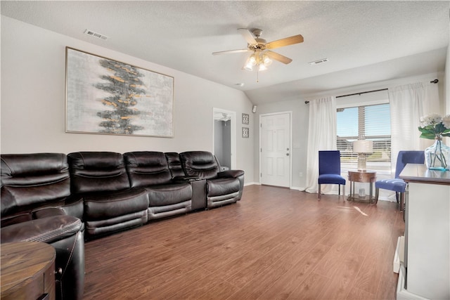 living room featuring a textured ceiling, dark hardwood / wood-style flooring, vaulted ceiling, and ceiling fan