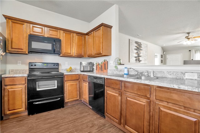 kitchen with light wood-type flooring, a textured ceiling, ceiling fan, sink, and black appliances