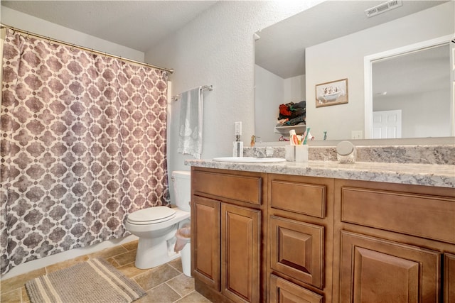 bathroom featuring tile patterned flooring, vanity, toilet, and a textured ceiling