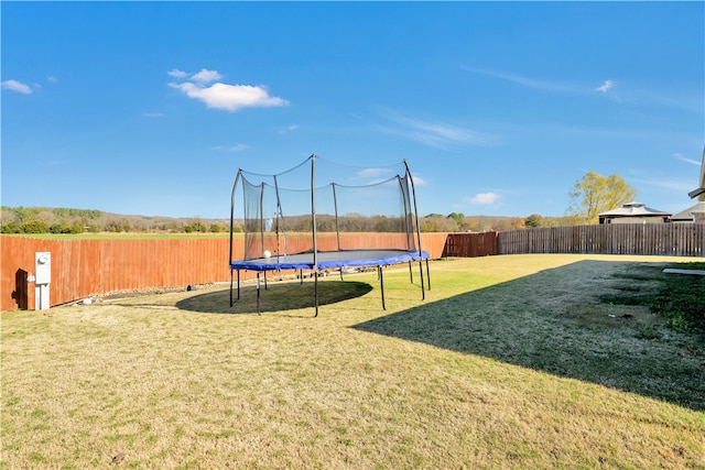 exterior space with a trampoline and a yard