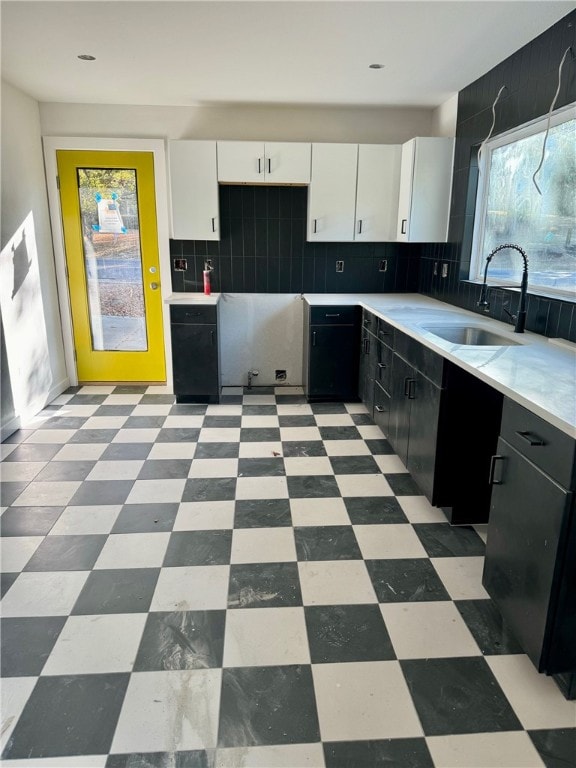 kitchen with backsplash, sink, and white cabinets