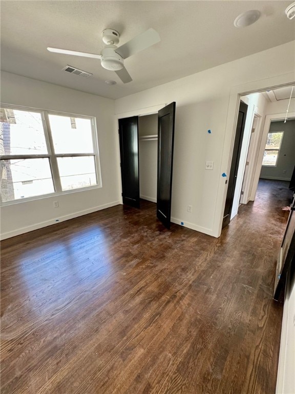 unfurnished bedroom with ceiling fan, dark hardwood / wood-style floors, and a closet