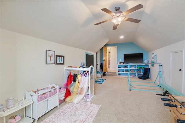 rec room with a textured ceiling, light colored carpet, ceiling fan, and lofted ceiling