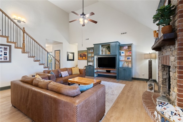 living room with light wood-type flooring, high vaulted ceiling, and ceiling fan